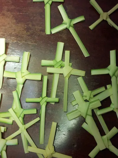 A heap of small crosses folded from green palm leaves