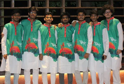 Young men in green and white panjabis printed with festive designs standing together