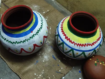 Two painted clay pots for Pongal, white with red, blue and green patterns