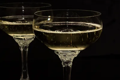 Glasses of sparkling drink glowing in low light