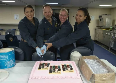 Colleagues cutting a cake together at work