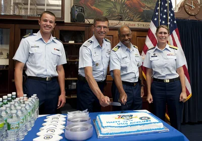 A team in uniform cutting a large cake