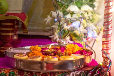 A puja thali with lit diyas, marigolds and flowers ready for the rakhi ceremony