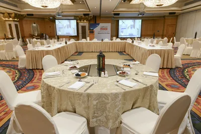 Round tables set for an iftar with a lantern at the centre
