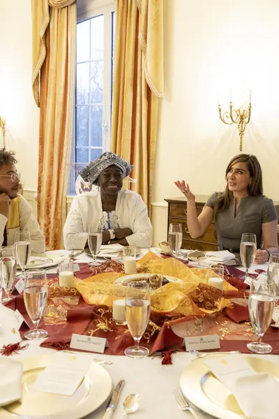 Guests talk over plates of food at an iftar table
