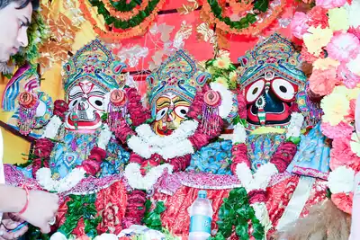 The images of Jagannath, Balabhadra and Subhadra on a chariot, covered in garlands