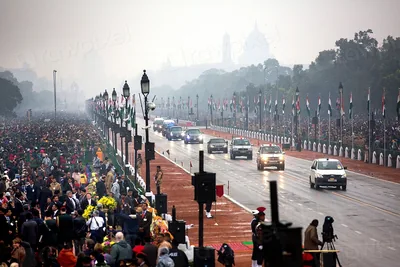 A misty morning view of the long parade avenue with stands of spectators and India Gate in the distance
