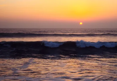 A golden sunset over gentle ocean waves