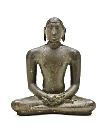 Old bronze statue of a Jain Tirthankara seated in calm meditation