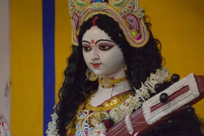 Close view of a Saraswati idol with a golden crown and white face