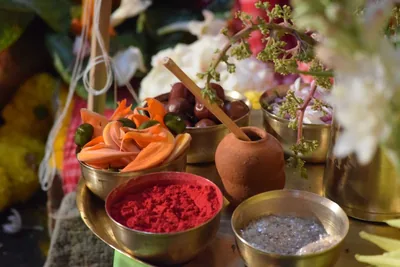 Brass bowls of red kumkum, rice, fruit and flowers set out for worship