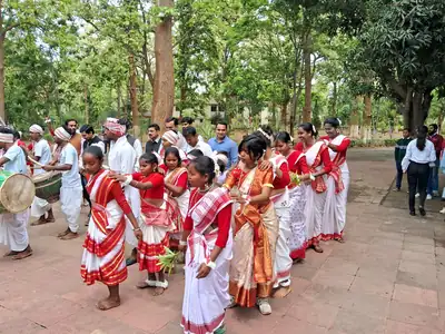 A long line of dancers in red bordered saris at a Sarhul gathering