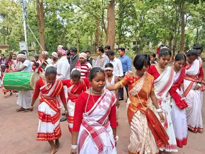 Dancers hold hands in a line while a crowd watches