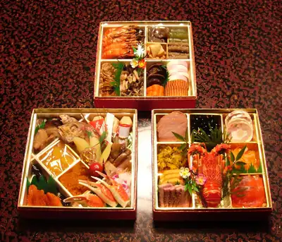 Three tiers of osechi New Year dishes in lacquer boxes