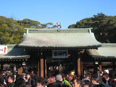 Large crowds waiting in front of a shrine gate in winter sunshine