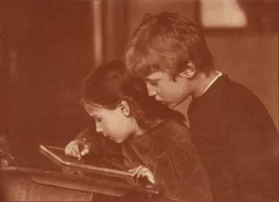A sepia photo of a brother and sister drawing together