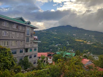 A hill town building with a green mountain behind