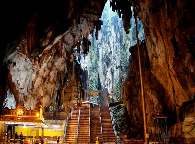 Steps leading up inside a huge limestone cave with a shrine