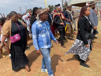 People in traditional clothes and modern clothes walk together in a lively crowd