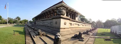 A long stone hall with a tiered roof on a raised platform lined with stone lions