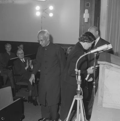 Black and white photo of Dr Sarvepalli Radhakrishnan in a long coat at a public event