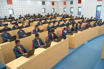 A large tiered lecture hall with rows of students at desks