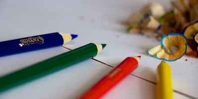 Red, green and blue pencils on a white desk