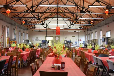 A dining hall decorated with red lanterns and yellow blossoms