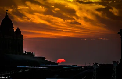 A red sun on the horizon under orange clouds