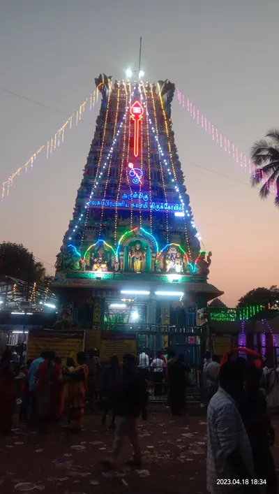 A temple tower lit with colourful lights at dusk