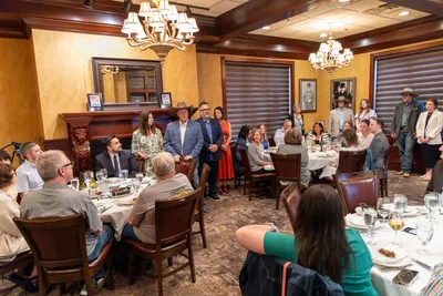 Hosts and guests at a long dinner table
