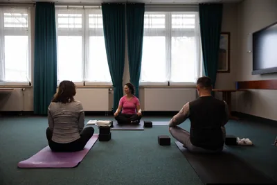 A teacher leading a small yoga class in a bright room